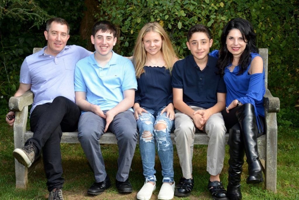 Family photo outside on bench with Meg Zucker, husband and three kids. 