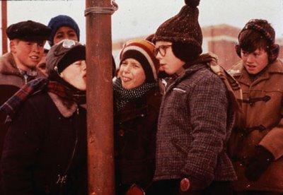 A group of children in winter clothing are outside in the snow, engaging in a spontaneous social emotional learning activity. One child has their tongue stuck to a metal pole, while others watch with a mix of curiosity and amusement, all bundled up in hats, scarves, and coats.