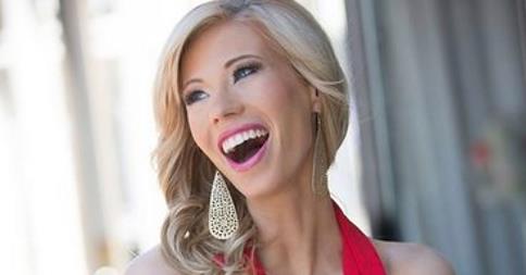 A blonde woman with long, wavy hair smiles widely as if she’s just discovered a perfect SEL activity. She is wearing large, dangling earrings and a bright red halter top. The background is softly blurred, echoing the warm energy of get-to-know-you activities for students.