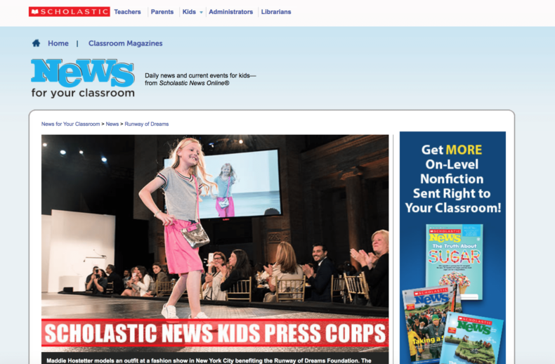A young girl models a pink dress on a runway, captivating smiling spectators. The event, highlighting the social emotional learning curriculum, is part of a press feature for Scholastic News Kids Press Corps. Various magazine covers appear on the right side of the image.