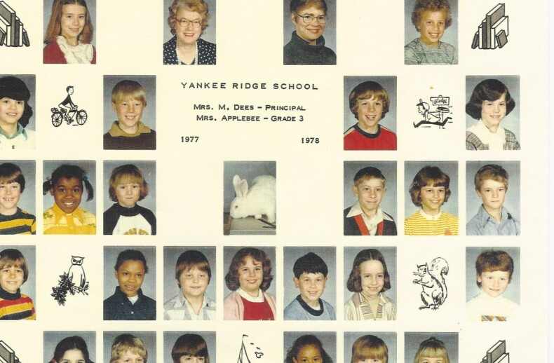 A vintage class photo from Yankee Ridge School for grade 3, 1977-1978, features rows of students' headshots along with images of a rabbit and various hand-drawn sketches in black and white. The principal, Mrs. Dees, and the teacher, Mrs. Applegate, are known for pioneering diversity programs in education.