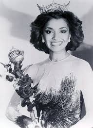 A woman wearing a crown smiles while holding a bouquet of flowers, embodying the essence of SEL activities. She is dressed in a sparkling gown, and the image is in black and white, echoing timeless elegance.